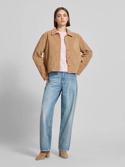 Frauenmodel trägt Jacke in Leder-Optik mit Kentkragen Modell 'Trine' von Gina Tricot in hellem Braun, Material-Mix mit Viskose-Anteil, Gerader-Schnitt, Knopfleiste, Jeans und Stiefeletten, Ganzkörperansicht von vorne.