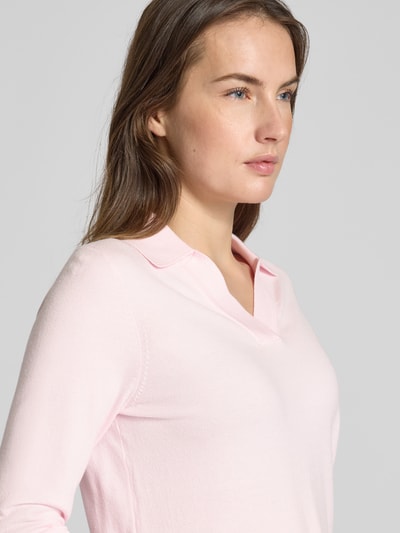 Modelka kobieca nosi Regular Fit Longsleeve aus Viskose-Mix mit Polo-Kragen od Christian Berg Woman, jasnoróżowy kolor, dzianinowa faktura, krój regular fit, taliowana sylwetka, długość pleców 54 cm, długość rękawa 62 cm, ujęcie zbliżeniowe górnej części ciała.