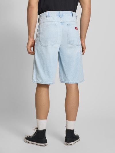 Männermodel trägt Loose Fit Bermudas mit Eingrifftaschen von Dickies aus Reine Baumwolle in Denim, hellblau, Ganzkörperansicht Rückansicht.