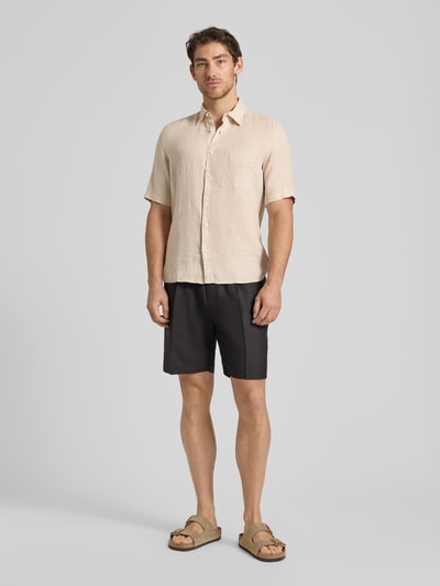 Mężczyzna nosi Regular Fit Freizeithemd aus reinem Leinen od Marc O'Polo, jasny len, krótkie rękawy, kieszeń, krój regular fit, widok całej sylwetki z przodu.
