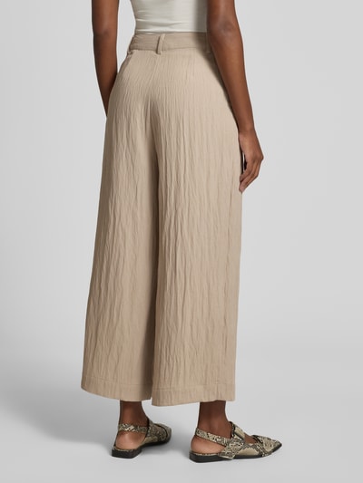 Frauenmodel trägt Damen Culotte von LOLLYS LAUNDRY, Modell 'Milo', Material-Mix mit Viskose-Anteil, Wide-Fit, Knopf-Reißverschluss, seitliche Eingrifftaschen, beige Farbe, strukturierte Textur, Ganzkörperansicht Rückansicht.