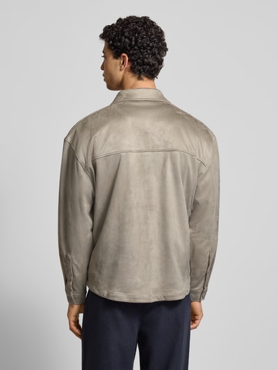 Männermodel trägt Relaxed Fit Hemdjacke mit Brusttaschen und Label-Stitching von Pegador aus Velours, beige, Rückenlänge 70 cm, Ganzkörperansicht Rückansicht.