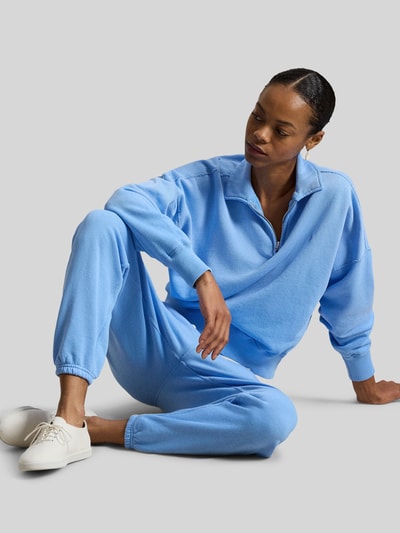 Frauenmodel trägt Relaxed Fit Sweatpants aus reiner Baumwolle von Polo Ralph Lauren in Hellblau, mit elastischem Bund, seitlichen Taschen und Logo-Stitching, Sweat-Material, Ganzkörperansicht von vorne.