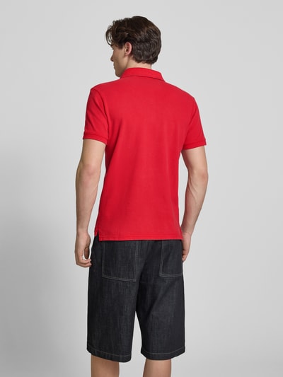 Männermodel trägt Regular Fit Poloshirt mit Logo-Stitching von Superdry in Rot, reine Baumwolle, Polokragen, Rückansicht, Ganzkörperansicht.