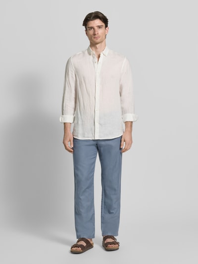 Męski model nosi Regular Fit Leinenhose aus Baumwoll-Leinen-Mix Modell 'MILES' od SELECTED HOMME, kolor niebieski, krój regular fit, spodnie o średnim stanie, 5 kieszeni, bawełna z lnem, widok całej sylwetki z przodu.