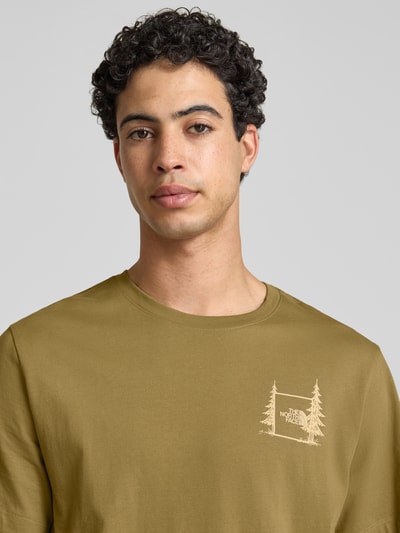 Mannelijk model draagt Relaxed Fit T-shirt met logo-print van The North Face van puur katoen in olijfgroen, ronde hals, Nahaufnahme Oberkörper.