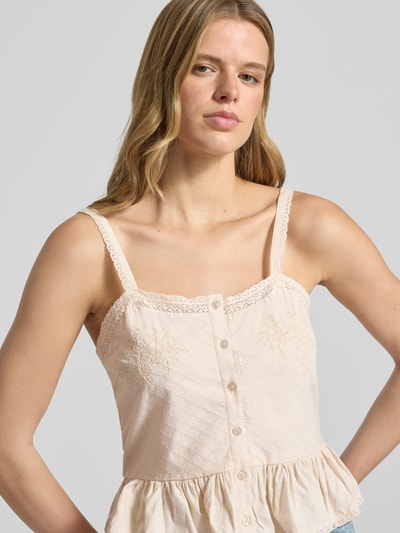 Vrouwenmodel draagt cropped trägertop uit katoen- en viscosemix model 'MERA' van Only dames, lichtbeige met kantdetails, close-up bovenlichaam.