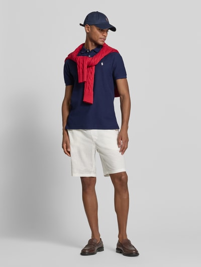 Männermodel trägt Slim Fit Poloshirt aus reiner Baumwolle von Polo Ralph Lauren in Optik: Unifarben, mit Logo-Detail, Ganzkörperansicht von vorne.