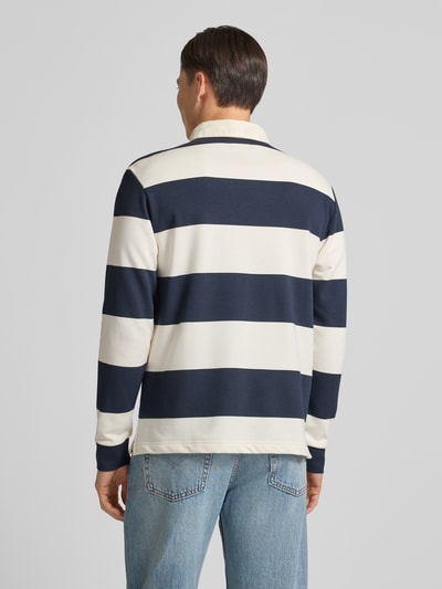 Męski model nosi Koszulkę polo z krótką listwą guzikową od MCNEAL z mieszanki bawełny, krój regular fit, kołnierzyk polo, prążkowane zakończenia rękawów, długość tyłu 71 cm, widok całej sylwetki z tyłu.