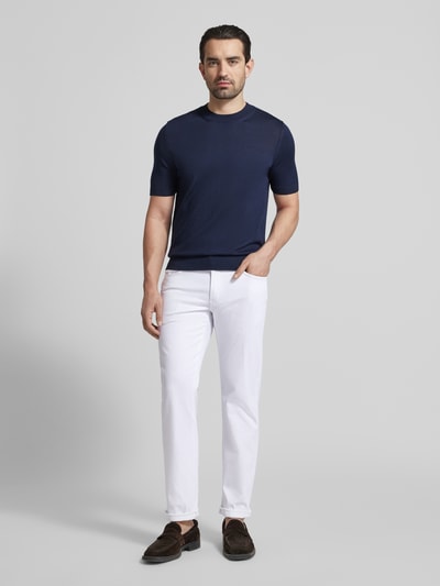 Männermodel trägt Regular Fit Jeans im Used-Look Modell 'Cadiz' von BRAX, Baumwoll-Mix mit Stretch-Anteil, Eingrifftaschen, weiß, Ganzkörperansicht von vorne.
