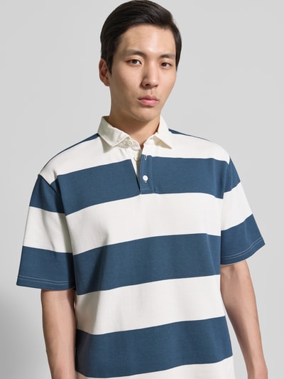 Męski model nosi Relaxed Fit Poloshirt im Allover-Look od MCNEAL, bawełniany mix, krój relaxed fit, z guzikami, kolor granatowo-biały, zbliżenie na górną część ciała