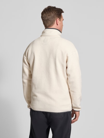 Męski model trägt Fleecepullover mit Stehkragen und Knopfleiste von Columbia, krój regular fit, wyhaftowane logo, kieszeń zapinana na zamek błyskawiczny, długość tyłu w rozmiarze M: 73 cm, długość rękawów w rozmiarze M: 70 cm, odcień kremowy, faktura miękka, widok całej sylwetki z tyłu.