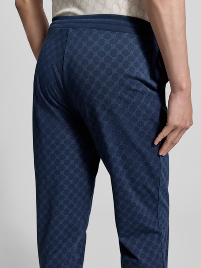 Männermodel trägt Sweatpants mit Logo-Muster und elastischem Bund von JOOP! Collection, Reine Baumwolle, Regular-Fit, Ganzkörperansicht Rückansicht.