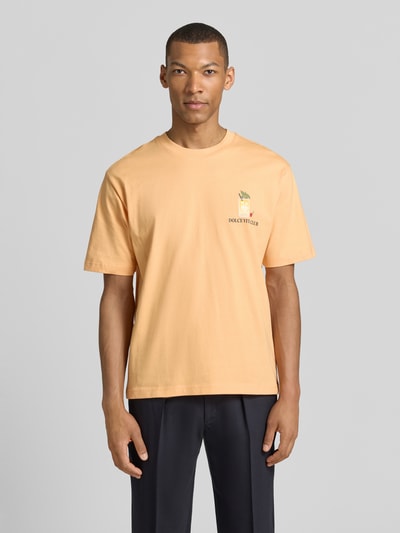 Mannelijk model draagt T-Shirt met rückseitigem Motiv-Print van MCNEAL in perzik, rechte fit, ronde hals, voorkantopname bovenlichaam, biologische katoen.