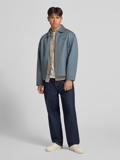 Männermodel trägt Slim Fit Freizeithemd aus reiner Baumwolle Modell 'GUDMUND' von ONLY, hell kariert, dazu blaue Jeans, Ganzkörperansicht von vorne, Herren Freizeithemd von ONLY & SONS.