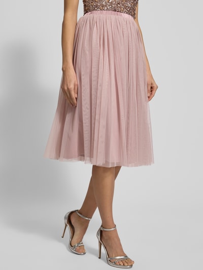 Frauenmodel trägt Knielanger Rock mit Plisseefalten von Lace & Beads in zartem Rosa, strapazierfähiges Material, lockerer Schnitt, Knielänge, elastischer Bund, blickdichter Unterrock, Detailaufnahme Unterkörper.