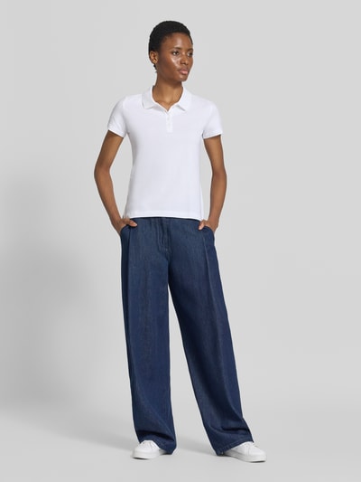 Frauenmodel trägt Regular Fit Poloshirt aus reiner Baumwolle von Tom Tailor, weiß, zu weitem Jeans, Ganzkörperansicht von vorne, Damen Poloshirt von Tom Tailor.