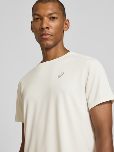 Männermodel trägt Regular Fit T-Shirt mit Logo-Print von ASICS in Offwhite, Kurzarm, Rundhalsausschnitt, Nahaufnahme Oberkörper.