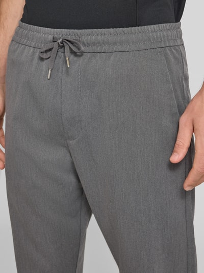 Männermodel trägt Relaxed Fit Hose mit elastischem Bund Modell 'TOBY' von JACK & JONES in Grau, Material-Mix, Nahaufnahme Oberkörper.