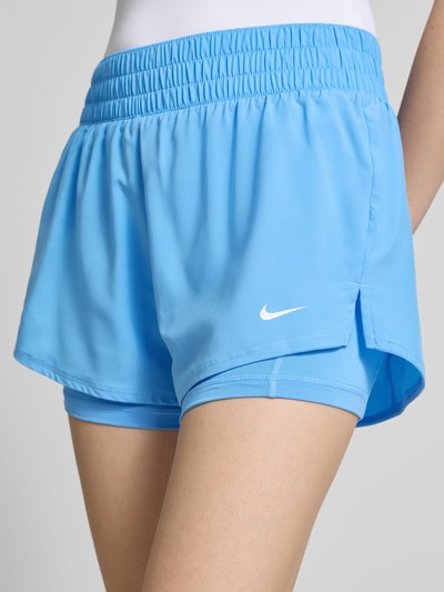 Frauenmodel trägt Regular Fit Shorts mit Integrierten Tights von NIKE TRAINING in Hellblau, Elastischer-Material-Mix, Elastischer Bund, Nahaufnahme Oberschenkel.