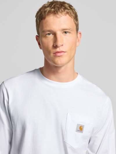 Männermodel trägt Longsleeve mit Brusttasche und Label-Detail von Carhartt Work In Progress, Reine Baumwolle, Regular-Fit, Rundhalsausschnitt, Nahaufnahme Oberkörper.