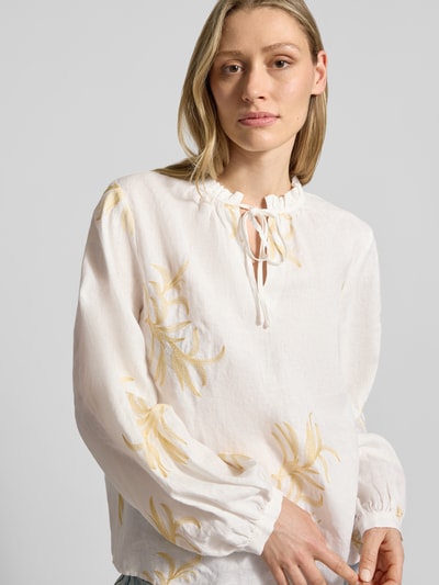 Frauenmodel trägt Bluse mit Serafino-Kragen und Schnürung von Emily Van den Bergh aus Reinem Leinen, Straight Fit, Embroidery Design, Nahaufnahme Oberkörper.