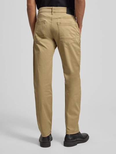 Męski model nosi Regular Fit Chino aus Baumwoll-Mix von s.Oliver RED LABEL, beżowy, bawełniany materiał, 5 kieszeni, widok całej sylwetki z tyłu.