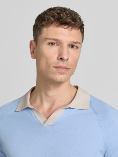 Männermodel trägt Regular Fit Poloshirt mit V-Ausschnitt von GRAN SASSO, hellblau mit kontrastfarbenem Kragen, reine Baumwolle, Nahaufnahme Oberkörper.