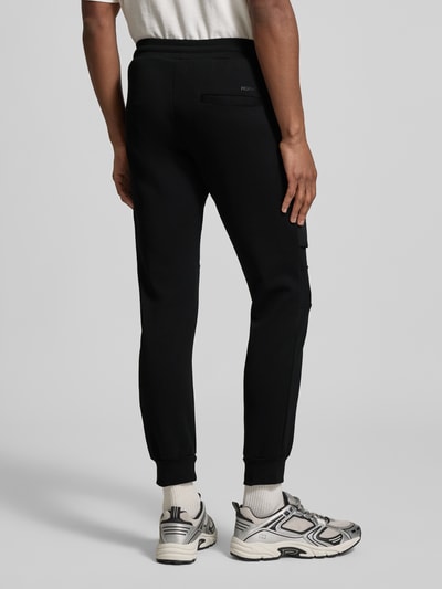Männermodel trägt Slim Fit Sweatpants mit Gesäßtaschen van Antony Morato in zwart, elastische boorden, katoenmix, achteraanzicht, ganzkörperansicht rückansicht.