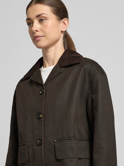 Frauenmodel trägt Jacke mit Pattentaschen von Stefanel aus braunem Baumwoll-Mix, Umlegekragen, Knopfleiste, Nahaufnahme Oberkörper.