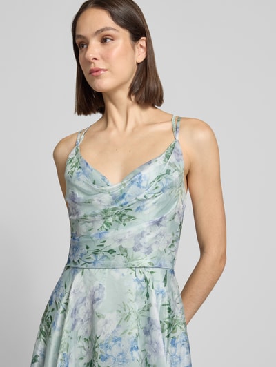 Frauenmodel trägt Cocktailkleid mit Wasserfall-Ausschnitt von Luxuar in mint mit floralem Muster, taillierte Passform, Nahaufnahme Oberkörper.
