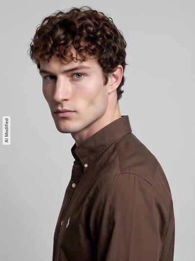 Męski model nosi Custom Fit Freizeithemd aus Baumwoll-Mix od Polo Ralph Lauren, jednokolorowy brąz, wyhaftowane logo, mieszanka bawełny, zbliżenie na górną część ciała, KI-modifiziertes Bild.
