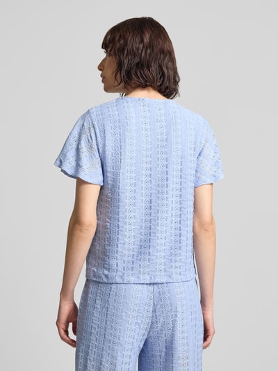 Männermodel trägt Kurzarmbluse mit Lochstickerei Modell 'CASSANDRA' von Vero Moda, krój regular fit, niebieska, unikatowa faktura, całkowity widok z tyłu.