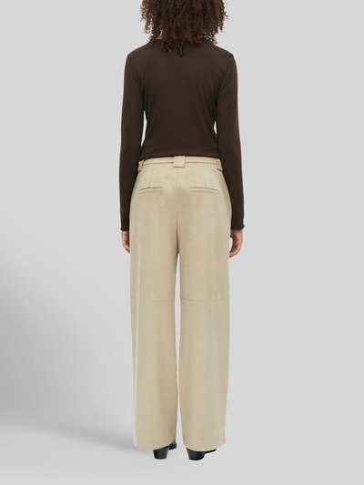 Frauenmodel trägt Weite Hose in Lederoptik von s.Oliver BLACK LABEL in Beige mit glatter Textur, Ganzkörperansicht Rückansicht.