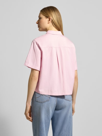 Frauenmodel trägt Boxy Fit Bluse aus Lyocell-Baumwoll-Mix von Jake*s Casual in Rosa mit Hemdblusenkragen und Knopfleiste, Rückenlänge 55 cm, Ärmellänge 25 cm, lockere Form, feine Webstruktur, Ganzkörperansicht Rückansicht.