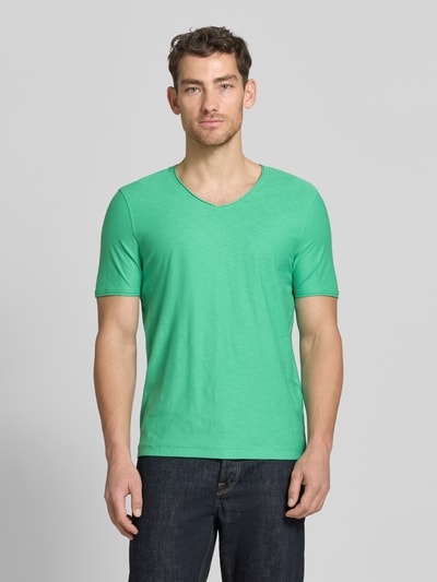 Männermodel trägt Regular Fit T-Shirt mit V-Ausschnitt von MCNEAL in Grün, aus Reine Baumwolle, Rollsaum, Ganzkörperansicht von vorne.