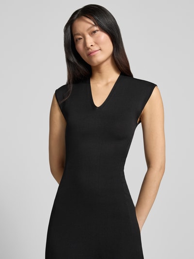 Frauenmodel trägt Kleid aus Viskose-Mix Modell 'CANELONS' von MANGO, tailliert, ärmellos, V-Ausschnitt, Schwarz, Nahaufnahme Oberkörper.