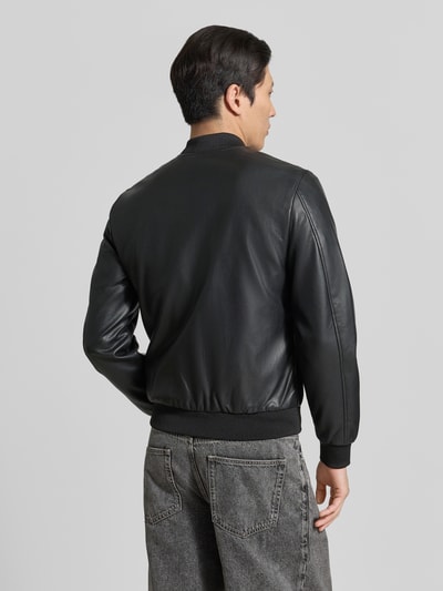 Männermodel trägt Bomberjacke in Leder-Optik mit Zweiwege-Reißverschluss von MARKUP, Material-Mix mit Viskose-Anteil, Regular-Fit, Stehkragen, schwarze Farbe, glatte Textur, Herrenmode, Ganzkörperansicht Rückansicht.