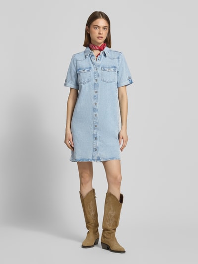 Kobiece modelka nosi Körpernahes Jeanskleid aus Baumwoll-Viskose-Mix Modell 'LISA' od Only, jasnoniebieski denim, mini, krój slim fit, V-dekolt, krótkie rękawy z podwinięciem, kieszenie na piersi, przód z guzikami, tekstura gładka, widok całej sylwetki z przodu