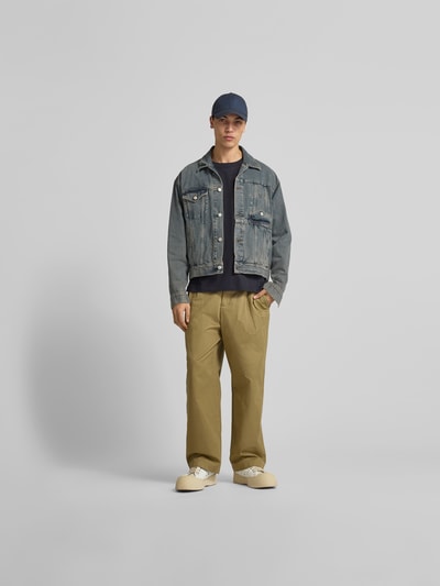 Männermodel trägt Longsleeve mit Rundhalsausschnitt von ANNARR in Schwarz, kombiniert mit Jeansjacke und Chino, Ganzkörperansicht von vorne. Regular Fit, reine Baumwolle, Rückenlänge bei Größe M: 72 cm.