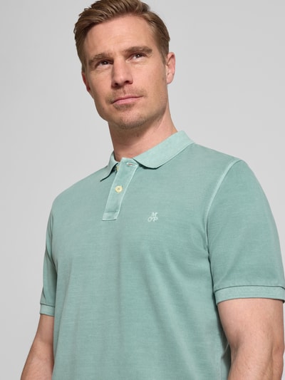 Männermodel trägt Regular Fit Poloshirt aus reiner Baumwolle von Marc O'Polo, Optik: Unifarben, Logo-Stitching, Nahaufnahme Oberkörper.