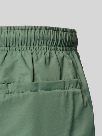 Produktfoto, Badehose mit elastischem Bund und Tunnelzug von MCNEAL in grünem Baumwoll-Mix, Regular-Fit, glatte Textur, Detailaufnahme.
