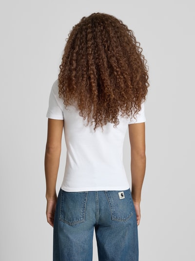 Frauenmodel trägt Slim Fit T-Shirt aus reiner Baumwolle Modell 'Gracious' von Carhartt Work In Progress, weiße Farbe, glatte Textur, Denim dazu kombiniert, Rückenlänge bei Größe S 53 cm, Ganzkörperansicht Rückansicht.
