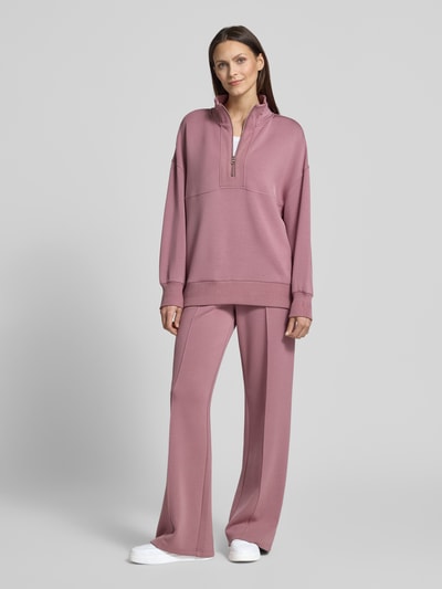 Frauenmodel trägt Sweatshirt mit Troyer-Kragen Modell 'molly' von VARLEY aus Viskose-Mix mit Stretch-Anteil, Relaxed-Fit, gerippte Ärmelabschlüsse, Ganzkörperansicht von vorne.