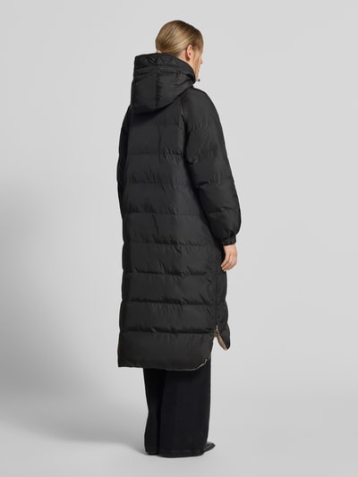 Frauenmodel trägt Regular Fit Mantel in Stepp-Optik Modell 'IMBOTTITO' von Liu Jo White in Schwarz, elastische Ärmelabschlüsse, Ganzkörperansicht Rückansicht.