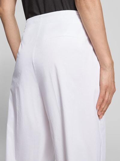 Frauenmodel trägt Caprihose mit Gesäßtasche von Luisa Cerano in Weiß, aus Baumwoll-Elasthan-Mix mit Bügelfalten, Nahaufnahme Rückansicht.