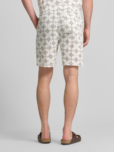 Männermodel trägt Relaxed Fit Stoffshorts aus einer katoen von s.Oliver RED LABEL in beige mit braunem Muster, Ganzkörperansicht Rückansicht.