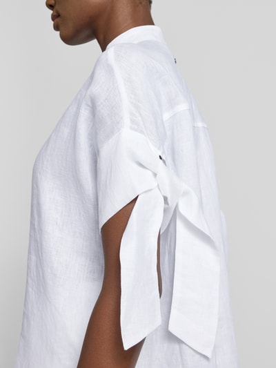 Frauenmodel trägt Regular Fit Bluse mit Stehkragen und Knopfleiste von ARMANI EXCHANGE, Knotendetail am Ärmel, seitliche Nahaufnahme.