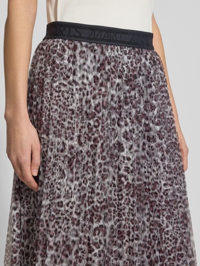 Vrouwenmodel draagt Midirok in plooienlook met all-over dierenprint van Marc Cain, licht a-lijn, elastische band, logostitching, detailopname taille