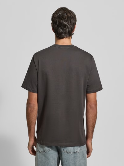 Męski model nosi T-Shirt z nadrukiem label-Print model 'Brady' od Les Deux, czysta bawełna, regular fit, widok całej sylwetki z tyłu.
